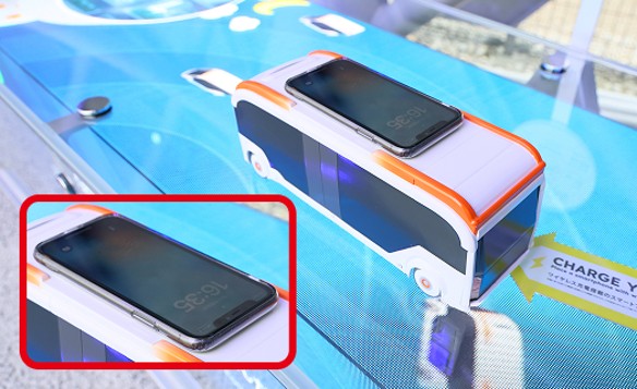 LEDビジョン上部のワイヤレス充電器でスマートフォンを充電している様子
