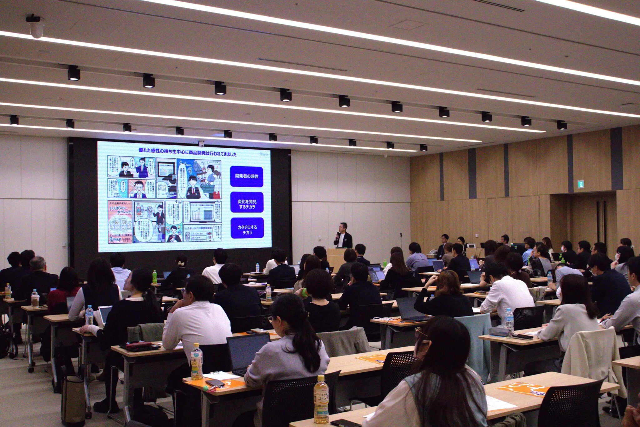 セミナー会場全景—前方の大型スクリーンと多数の参加者が講演を聴講する様子