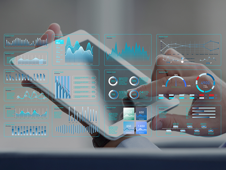 タブレットを操作する手元に各種データダッシュボードが重ね表示された様子