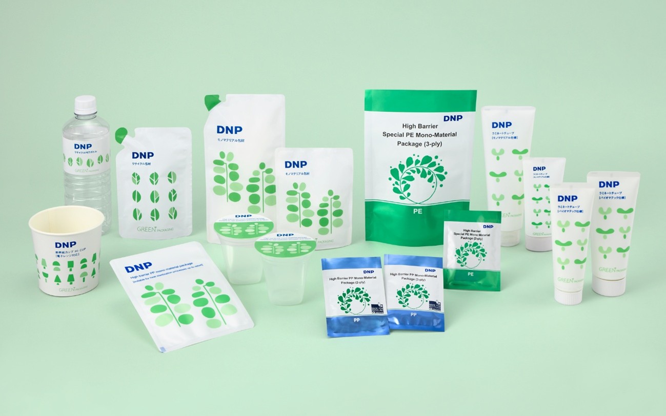 DNPの環境配慮パッケージ「GREEN PACKAGING」の多様な製品ラインアップ。パウチやチューブ、紙カップ、PETボトルなど、さまざまな形状のパッケージが並ぶ様子。