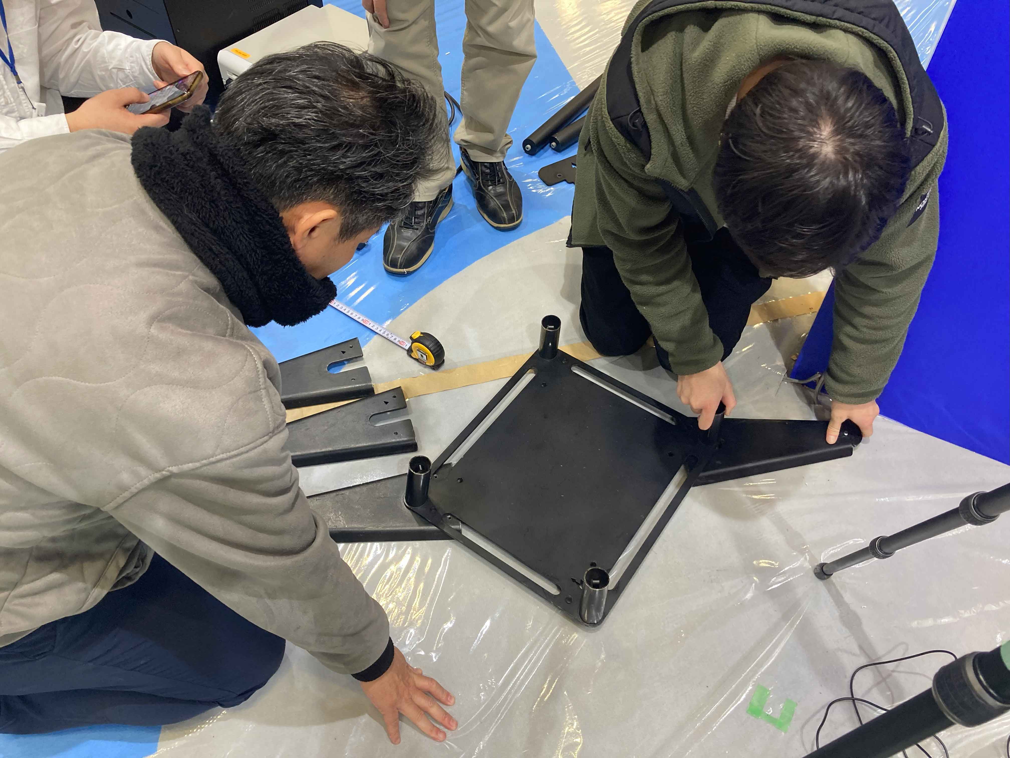 底面板に転倒防止版を取り付ける様子