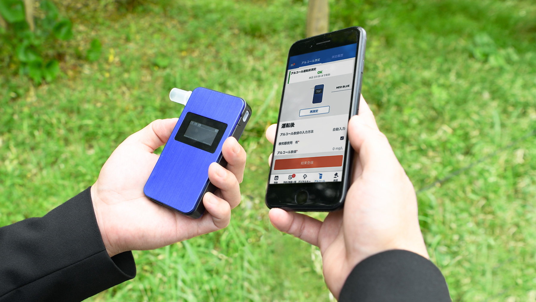 屋外でアルコール検知器とスマホアプリを利用して車両の解錠を行っている様子